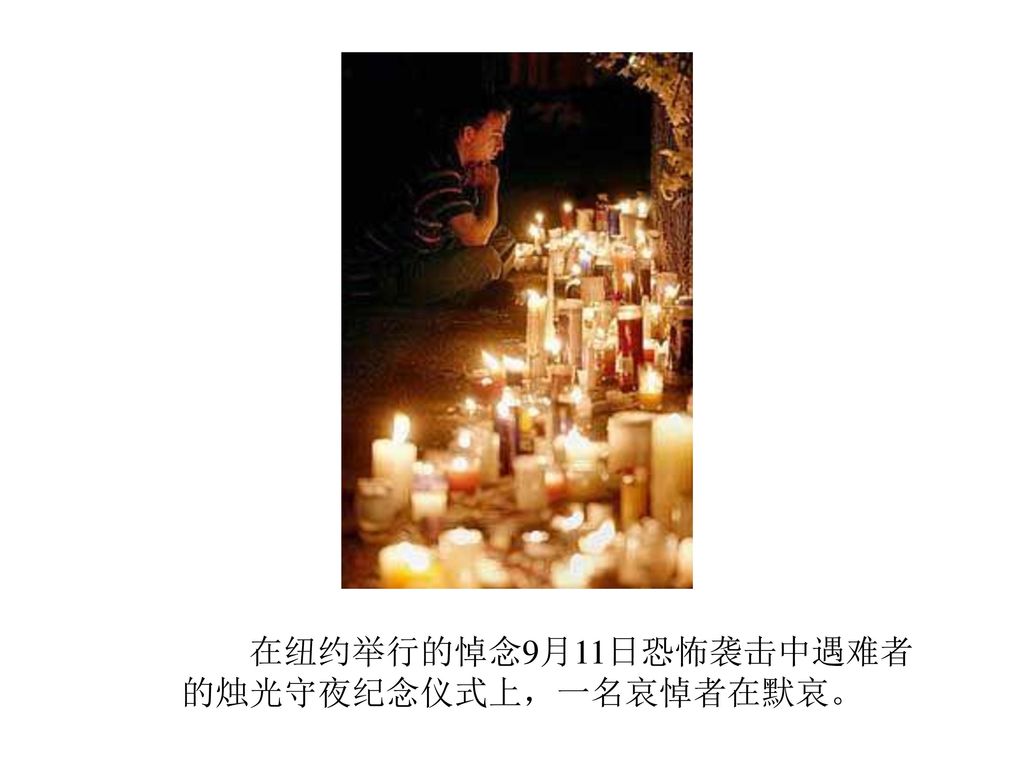 在纽约举行的悼念9月11日恐怖袭击中遇难者 的烛光守夜纪念仪式上，一名哀悼者在默哀。